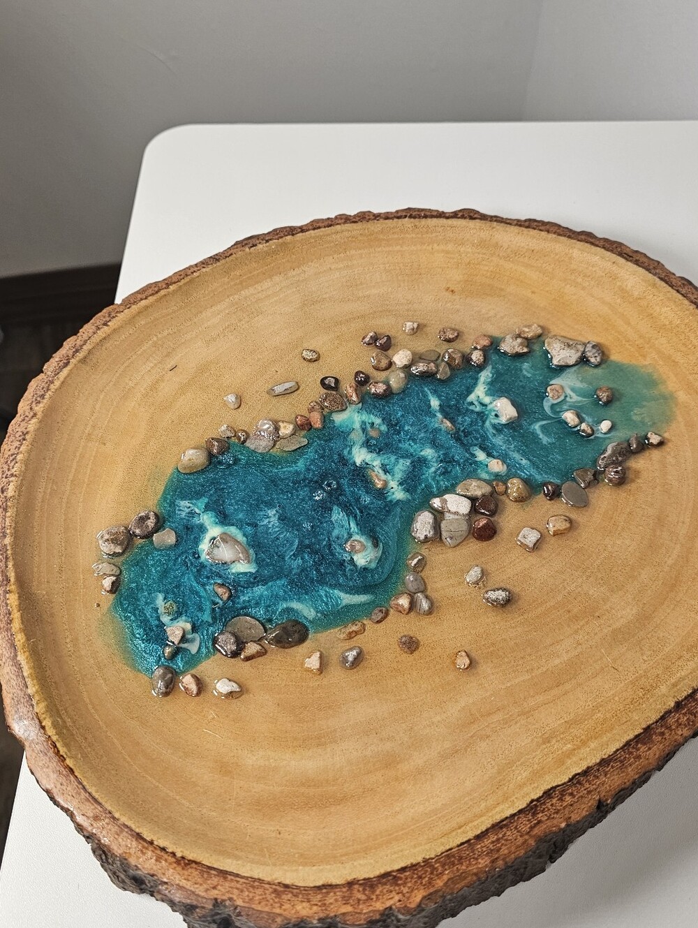 handcrafted live-edge wooden slab centerpiece featuring an epoxy resin ocean sce